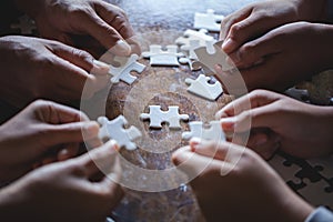 Hands of diverse people assembling jigsaw puzzle, Youth team put