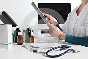 Hands doctor using digital tablet close up at desk in office