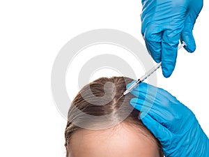 Hands of a doctor and woman with hair loss problem receiving injection on white background