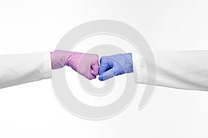 hands of doctors in gloves make fist bump gesture