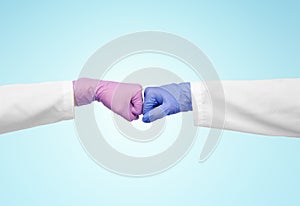 hands of doctors in gloves make fist bump gesture