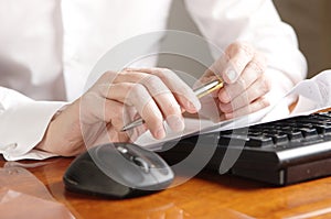 Hands with document on a computer keyboard