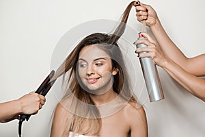 Hands doing hairstyle to young beautiful naked girl.