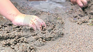 Hands drawing heart on sand