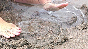 Hands drawing heart on sand