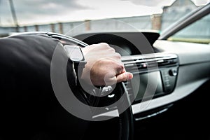 Hands of a driver on steering wheel of a car