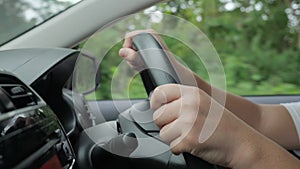 Hands of driver on steering wheel, driving a car concept, close up