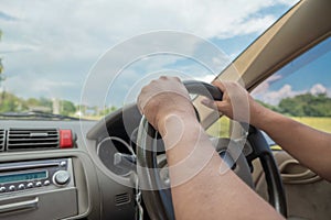 Hands driving a car in home town, safety drive and car insurance concept