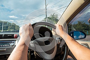 Hands driving a car in home town, safety drive and car insurance concept