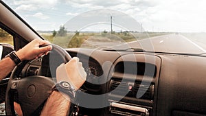 Hands driving car wheel