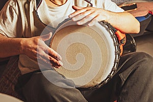 Hands of a drummer playing the ethnic percussion musical instrument djembe