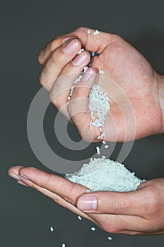 Hands dumping polymer resin