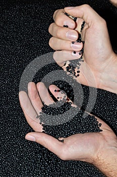 Hands dumping polymer resin