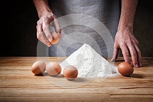 Hands, eggs and flour. Basic dough for fresh egg pasta recipe.