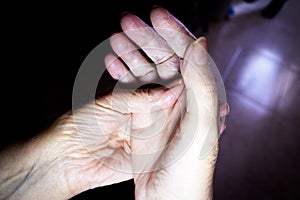 Hands of elderly woman doing a selfmassage