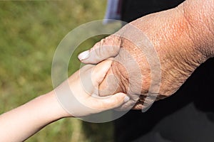 Hands of an elderly woman holding a young woman`s hand. There is an isolate, or without it