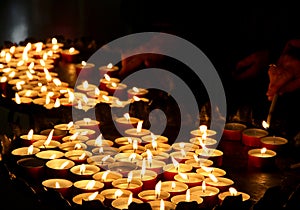 Hands of an elderly woman lighting a candle
