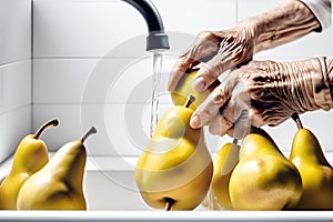 The hands of an elderly woman wash pears