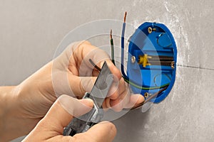 Hands of electrician striping the insulation of wires