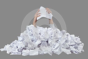 Hands with empty crushed paper reaches out from big heap of crumpled papers