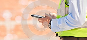 Hands of engineer on construction site, typing on phone and checking email for building schedule with mockup