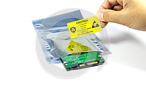 Hands of the engineers who are labeling the ESD protection label on the bag,The yellow CAUTION label for Electrostatic Sensitive photo