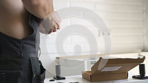 Hands of erector assembling furniture at home. Technologist using hammer