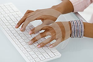 Hands of ethnic businesswoman typing