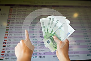 Hands with euro money over currency exchange rates