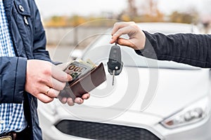 Hands exchanging with car keys and euro banknotes