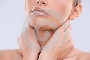 Hands, face and mouth with woman for beauty, makeup with shine and cosmetics on white background. Skin, lipstick or balm