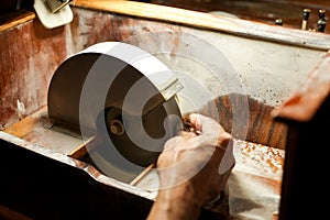Hands during faceting of gemstone.