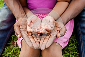 Hands of family together in green park - family unity and peace