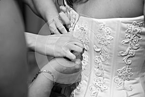 Hands fastening back of dress