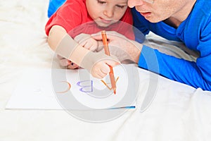 Hands of father and child writing letters