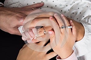 Hands of father, mother, daughter keep little feet baby.