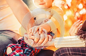 Hands of father, mother, keep hand little baby. Parents hold the baby hands. Closeup of baby hand into parents hands