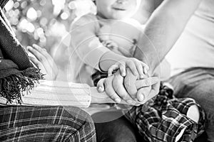 Hands of father, mother, keep hand little baby. Parents hold the baby hands. Closeup of baby hand into parents hands