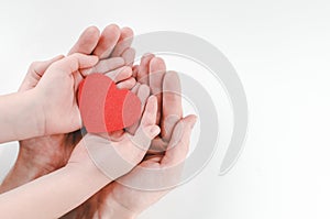 Hands of father and son holding red heart, heart health insurance, family day, world heart day