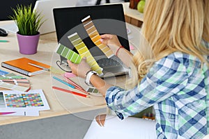 Hands of female designer in office working with colour samples