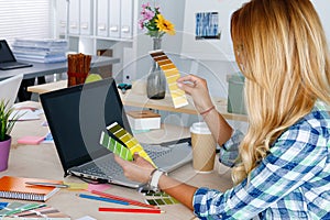 Hands of female designer in office working with colour samples