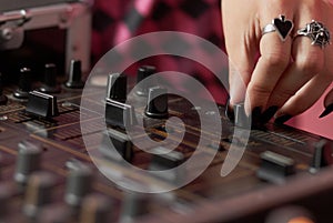 Hands of female DJ mixing music