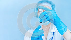 Hands of female doctor with coronavirus vaccine close up on blue background banner. COVID-19 vaccination concept creative banner.