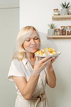 In the hands of a female nutritionist is a plate with a ready-made dish of zucchini and feta cheese