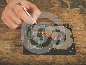 Hands fixing a harddrive on desk