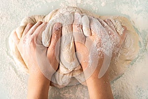 hands in flour crumple the dough for pizza or pies, the process of cooking bakery products