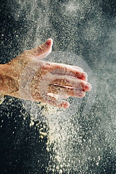 Hands with flour on a dark background