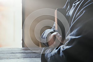 Hands folded in prayer on a Holy Bible in church concept for faith