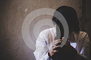 Hands folded in prayer on a Holy Bible in church concept for faith