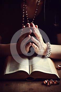 Hands folded in prayer on a Holy Bible in church concept for faith AI generated